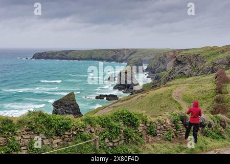 Rambler genießt an einem stürmischen Frühlingstag England Großbritannien den spektakulären Blick auf die Küste der Bedruthan Steps North Cornwall Stockfoto