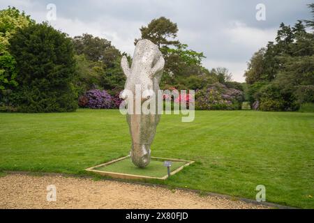 Vor dem Palace House, das einst das Torhaus der Beaulieu Abbey mit Rhododendronbüschen war, gehen Pferde aus Skulpturen Stockfoto