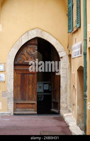 Antibes, Frankreich - 12. November 2022: Die Seitentür der Kapelle Saint-Bernardin ist aus massivem Nussbaum und stammt vom 20. März 1581. Stockfoto