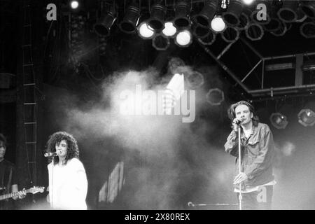 DEACON BLUE, PYRAMID STAGE, GLASTONBURY 1990: Ricky Ross und Lorraine McIntosh von Deacon Blue auf der Pyramid Main Stage beim Glastonbury Festival, Pilton Farm, Somerset, England, Juni 1990. 1990 feierte das Festival sein 20-jähriges Bestehen. Foto: ROB WATKINS. INFO: Deacon Blue ist eine schottische Pop-Rock-Band, die 1985 gegründet wurde und für ihre gefühlvollen Melodien und introspektiven Texte bekannt ist. Sie erlangten große Popularität mit Hits wie „würde“ und „Real Gone Kid“ und wurden in den späten 1980er und 1990er Jahren zu einem bedeutenden Akt Stockfoto