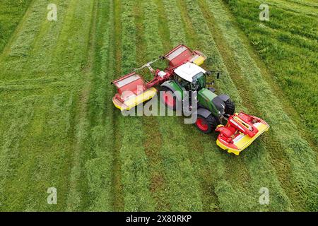 Themenfoto: Landwirtschaft. Ein Landwirt faehrt mit seinem Traktor ueber eine Wiese und maeht. Schlepper, Maehwerk, gemaehte Wiese, Weide, Gras, maehen, Landschaft, Traktorspuren. Maehmaschine, Doppelmaehwerk, Maehkombination, Schmetterlingsmaehwerk. *** Thema Foto Landwirtschaft Ein Landwirt fährt seinen Traktor über eine Wiese und mäht Traktor, Mähen, Mähen, Wiesen, Weiden, Gras, Mähen, Landschaft, Traktorketten Mähmaschine, Doppelmäher, Mähkombination, Schmetterlingsmäher Stockfoto