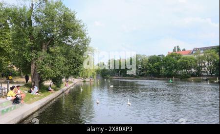 Berlin, Deutschland, 21. Mai 2024, Blick über den Landwehrkanal am Urbanhafen in Richtung Planufer mit alten Bäumen und Wohngebäuden in der Stockfoto