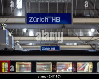 Zürich, Schweiz - 16. Mai 2024: Innenraum des HB-Bahnhofs Zürich mit blauem Zürcher HB-Schild, Zug, moderne Deckenkonstruktion. Stockfoto