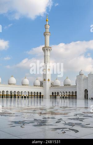 Das elegante Minarett erhebt sich über der Scheich-Zayed-Moschee und zeigt islamische Architektur vor einem blauen Himmel. Stockfoto