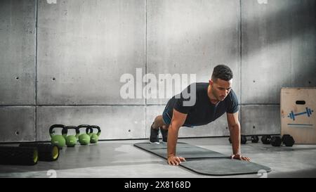 Online-Workout-Service: Professionelle Trainerübungen, Video-Tutorial, Virtuelles Training. Schöner schwarzer Athletic-Trainer, der zeigt, wie man Liegestütze macht. Weitwinkelaufnahme Stockfoto