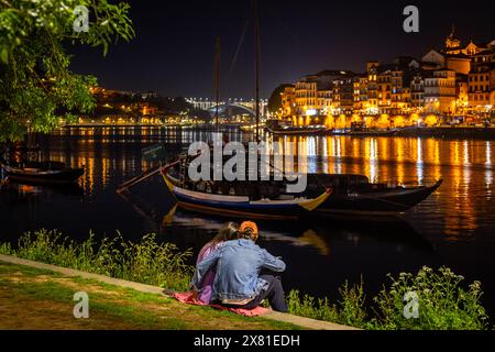 Ein Paar am Kai Vila Nova de Gaia in Richtung Cais da Ribeira bei Nacht, Porto, Portugal Stockfoto