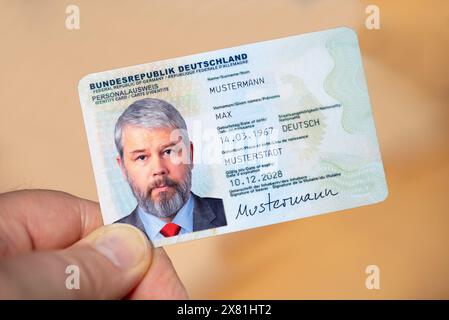Eine Hand hält einen deutschen Personalausweis mit einem etwa 50-jährigen Geschäftsmann Stockfoto