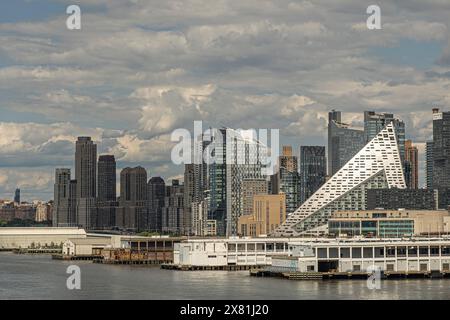 New York, NY, USA - 1. August 2023: New York, NY, USA - 1. August 2023: Dreiecksförmiger weißer Apartmentkomplex an der 57. West. Blau-graue Wolkenlandschaft und Stockfoto