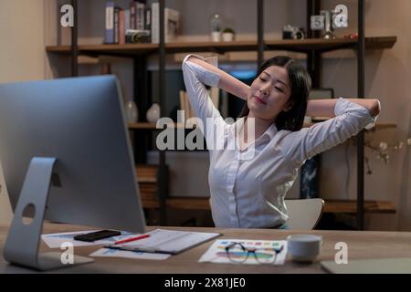 Junge Frau, die spät in der Nacht arbeitet. Stockfoto
