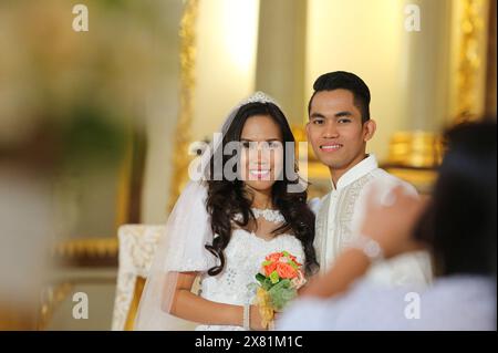 Manila, Philippinen. 22. Mai 2024: Schöne glückliche Hochzeit des jungen philippinischen Paares. Braut und Bräutigam, verheiratet mit katholischem Priester in der philippinischen Hauptstadt. Heute wurde das absolute Scheidungsgesetz vom Repräsentantenhaus verabschiedet. Eine historische Abstimmung, ein weiterer Schritt für Aktivisten, die die Legalisierung der Scheidung als Menschenrecht verteidigen und die Auswirkungen des Verbots auf Millionen von Frauen, die Opfer häuslicher Gewalt sind, verurteilen. Mit Vatikanstadt sind die Philippinen immer noch das einzige Land der Welt, in dem die Scheidung wegen des starken religiösen Einflusses der mächtigen römischen Katheterkirche illegal ist. Quelle: Kevin Izorce/Alamy Live News Stockfoto