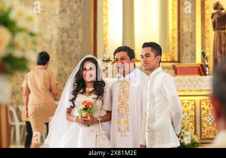 Manila, Philippinen. 22. Mai 2024: Schöne glückliche Hochzeit des jungen philippinischen Paares. Braut und Bräutigam, verheiratet mit katholischem Priester in der philippinischen Hauptstadt. Heute wurde das absolute Scheidungsgesetz vom Repräsentantenhaus verabschiedet. Eine historische Abstimmung, ein weiterer Schritt für Aktivisten, die die Legalisierung der Scheidung als Menschenrecht verteidigen und die Auswirkungen des Verbots auf Millionen von Frauen, die Opfer häuslicher Gewalt sind, verurteilen. Mit Vatikanstadt sind die Philippinen immer noch das einzige Land der Welt, in dem die Scheidung wegen des starken religiösen Einflusses der mächtigen römischen Katheterkirche illegal ist. Quelle: Kevin Izorce/Alamy Live News Stockfoto