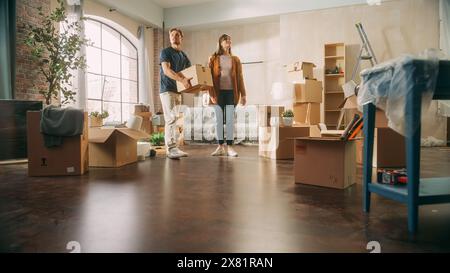 Familie neues Haus Einzug: Glückliches und aufgeregtes junges Paar betreten neu gekauftes Apartment. Schöne Familie, Die Sich Gerne Umsieht. Modernes Zuhause bereit für Dekorationen. Stockfoto