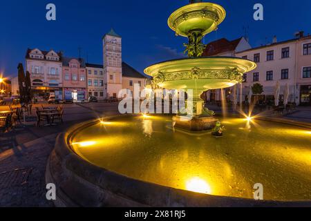 Der Brunnen auf dem Masaryk-Platz in Karviná aus nächster Nähe, Masaryk-Platz am Abend bei Sonnenuntergang, Rathaus im Hintergrund Stockfoto