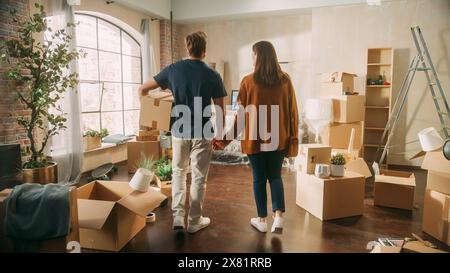 Familie neues Haus Einzug: Glückliches und aufgeregtes junges Paar betreten neu gekauftes Apartment. Schöne Familie Hält Glücklich Die Hände. Modernes Zuhause bereit für Dekorationen Stockfoto