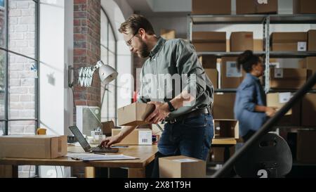 Geschäftiger Tag im Lager. Multikulturelle Mitarbeiter bei der Arbeit im Ladenlager. Kleinunternehmer, die an Notebooks arbeiten, Pakete für die Lieferung vorbereiten und verpacken. Stockfoto