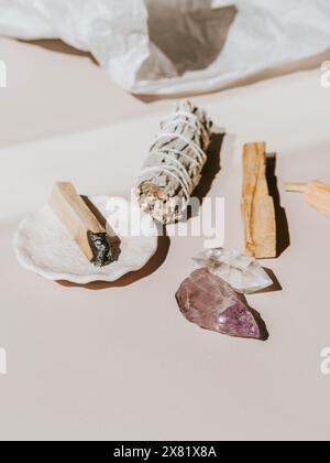 Weißer Salbei und Palo Santo und Amethyst und Quarzkristalle auf einem hellbeigen Hintergrund. Ein Satz Weihrauch zur Begasung Stockfoto