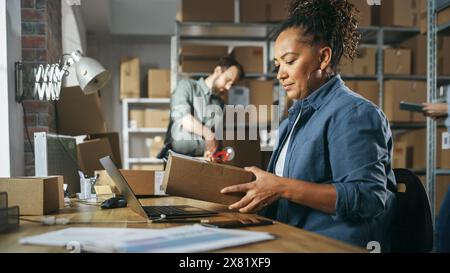 Multikulturelles Team von Lagermitarbeitern bei der Arbeit im Lagerraum des Einzelhandels. Eigentümer kleiner Unternehmen und Lagerbestandsmanager, die an Notebooks, Tablets und Paketen für die Lieferung arbeiten. Stockfoto