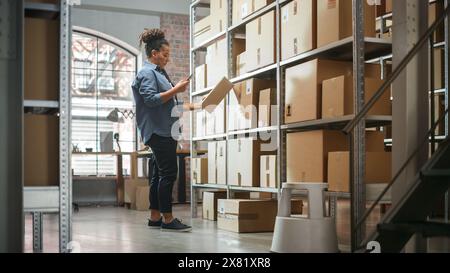 Warehouse Inventory Manager scannt mit dem Smartphone einen Barcode auf dem Paket und bereitet einen kleinen Karton für das Porto vor. Schwarzer, multiethnischer Eigentümer eines kleinen Unternehmens, der im Lager arbeitet. Stockfoto