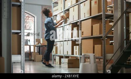 Warehouse Inventory Manager scannt mit dem Smartphone einen Barcode auf dem Paket und bereitet einen kleinen Karton für das Porto vor. Schwarzer, multiethnischer Eigentümer eines kleinen Unternehmens, der im Lager arbeitet. Stockfoto