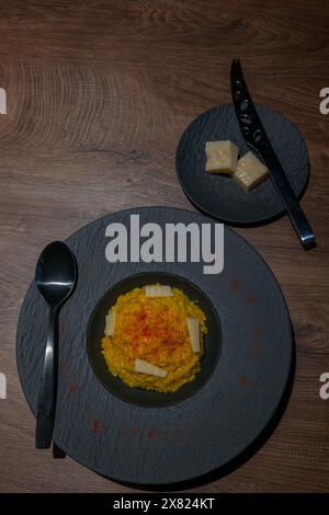 Eleganter Teller mit Risotto alla Milanese mit Safran und Parmesan in Lugano, Tessin, Schweiz. Stockfoto