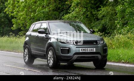 Stony Stratford, Großbritannien - 22. Mai 2024: 2015 Range Rover Evoque Auto fährt auf einer britischen Straße an einem nassen Tag Stockfoto