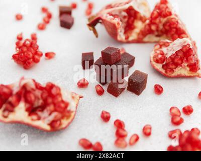 Hausgemachte kandierte Fruchtgelee mit Granatapfelfrüchten auf weiß. Flache Lage, Draufsicht. Stockfoto