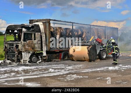 Pleidelsheim, Deutschland. Mai 2024. Auf der Autobahn A81 steht ein ausgebrannter Lkw mit einer Papierrolle daneben. Der Lkw, beladen mit Papierrollen von insgesamt 20 Tonnen, hatte zuvor aus unbekannten Gründen Feuer gefangen. Wegen des brennenden Lkws wurde die A81 vorübergehend vollständig geschlossen, und die Polizei kündigte an, dass die Bergungsoperation am Mittwochabend gegen 22 Uhr beginnen werde. Quelle: Andreas Rometsch/KS-Images.de/dpa/Alamy Live News Stockfoto