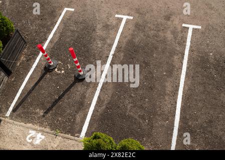 Nahaufnahme der leeren Parkplätze in der Nähe des Handelszentrums mit reserviertem Parkplatz. Parkpfosten. Draufsicht. Stockfoto