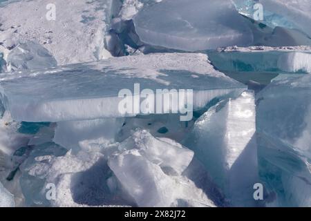 Der natürliche Winterhintergrund mit Bruchstücken von blauem Eis und Haufen von Eisschollen am Baikalsee an einem sonnigen frostigen Tag. Abstrakter kalter Hintergrund, Stockfoto