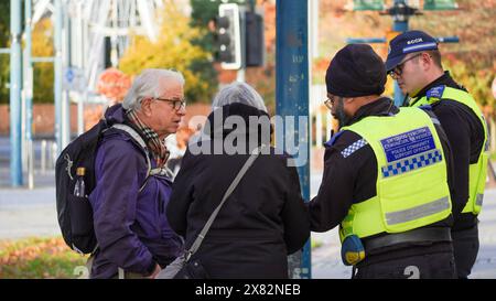 Cardiff, Wales, 29. Oktober 2023: Ältere Besucher von Cardiff bitten die örtliche Polizei um Hilfe im Stadtzentrum von Cardiff. Die Polizisten helfen ihnen Stockfoto