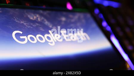 Viersen, Deutschland - 9. Mai. 2024: Nahaufnahme des Smartphones mit Logo-Schriftzug des Google Earth-Programms auf der Computertastatur Stockfoto