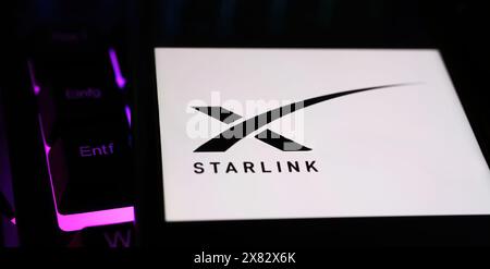 Viersen, Deutschland - 9. Mai. 2024: Nahaufnahme eines Smartphones mit Logo-Schriftzug der Sternenkonstellation Starlink auf der Computertastatur Stockfoto