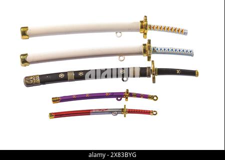 Nahaufnahme einer Sammlung von Miniatur-Spielzeugschwertern in bunten Degen, einschließlich Katana und Wakizashi isoliert auf weißem Hintergrund. Stockfoto