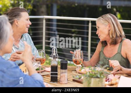 Verschiedene ältere Freundinnen, die im Freien essen Stockfoto