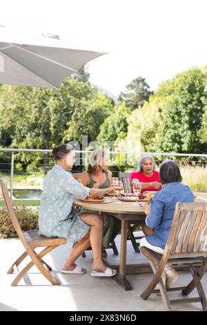Verschiedene ältere Freundinnen genießen das Essen im Freien Stockfoto