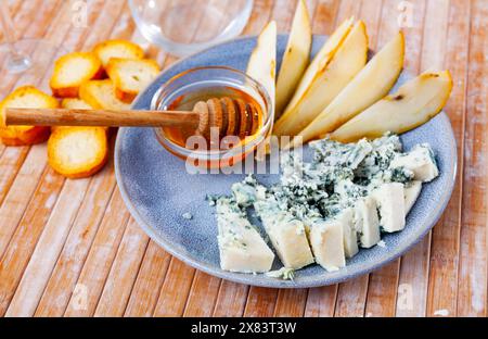 Roncari-Blauschimmelkäse, serviert auf dem Teller mit Birne, Croutons und Honig Stockfoto