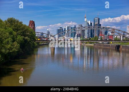 Der Main mit Regionalbahn auf der Deutschherrnbrücke und der Skyline von Frankfurt am Main in Hessen Stockfoto