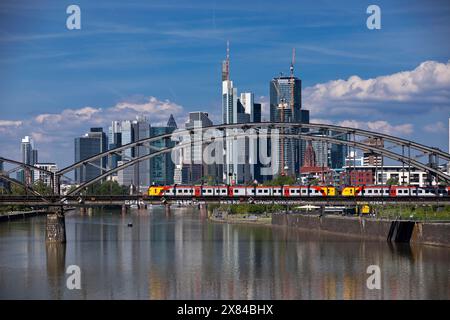 Der Main mit Regionalbahn auf der Deutschherrnbrücke und der Skyline von Frankfurt am Main in Hessen Stockfoto