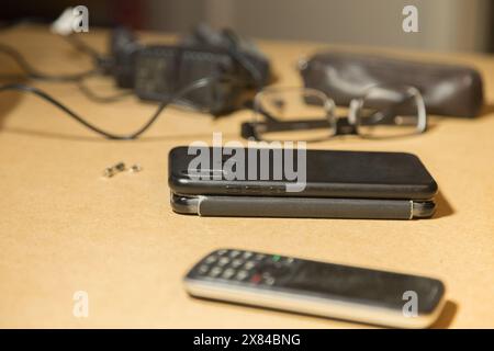 Zwei Smartphones und ein Telefon sind auf dem Desktop. Nahaufnahme. Stockfoto