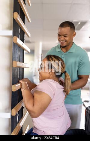 Birassische weibliche Querschnittslähmung mit Hilfe eines Therapeuten in der Reha Stockfoto