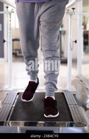 Im Rehabilitationszentrum des Fitnessstudios, männlicher Patient, der während der Reha auf dem Laufband läuft Stockfoto