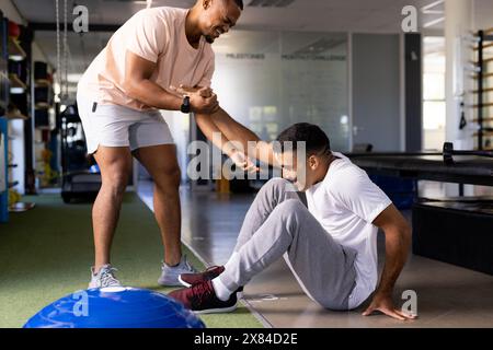 Im Rehabilitationszentrum behandelte birassische männliche Physiotherapeutin den Patienten Stockfoto