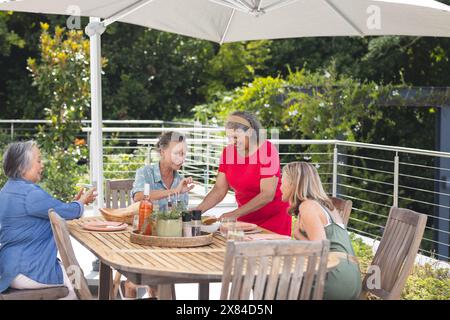 Verschiedene ältere Freundinnen, die im Freien essen Stockfoto