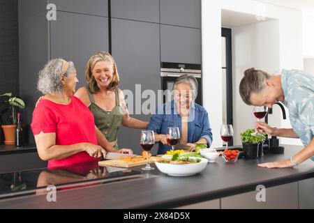 Verschiedene ältere Freundinnen lachen, zubereiten zu Hause Essen Stockfoto