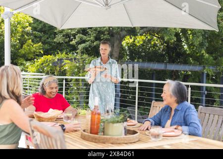 Verschiedene ältere Freundinnen, die im Freien essen Stockfoto