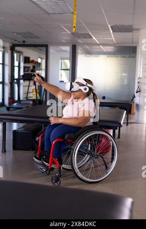 Eine birassische Querschnittsgelähmte Patientin mit VR-Headset im Rehabilitationszentrum Stockfoto