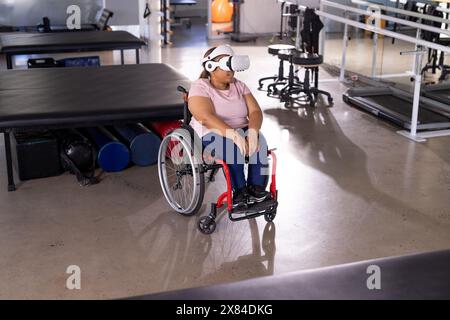 Eine birassische Querschnittsgelähmte Patientin mit VR-Headset im Rehabilitationszentrum Stockfoto