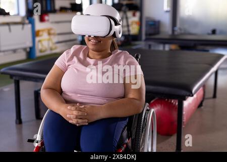 Eine birassische Querschnittsgelähmte Patientin mit VR-Headset im Rehabilitationszentrum Stockfoto