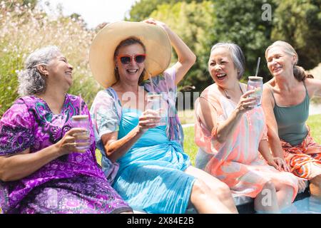 Im Freien lachen verschiedene ältere Freundinnen am Pool Stockfoto