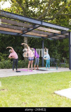 Im Freien, verschiedene ältere Freundinnen dehnen und Yoga machen Stockfoto